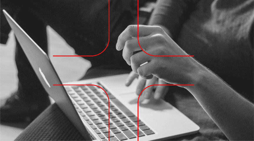 Immagine in bianco e nero di mani sopra un PC, con un disegno a forma di croce rossa.